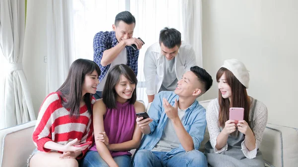 young people using  phones and smiling  happily