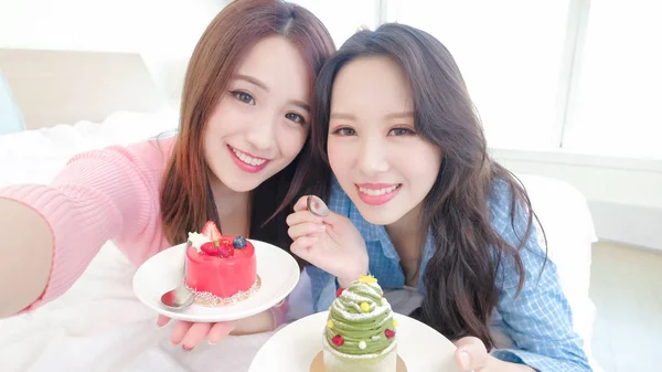 Két Szépség Vesz Selfie Boldogan Evés Sütemények Ágyon — Stock Fotó