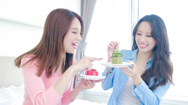 Zwei Schöne Frauen Die Kuchen Auf Dem Bett Essen — Stockfoto