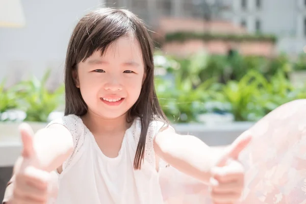 Menina bonito com polegares para cima — Fotografia de Stock