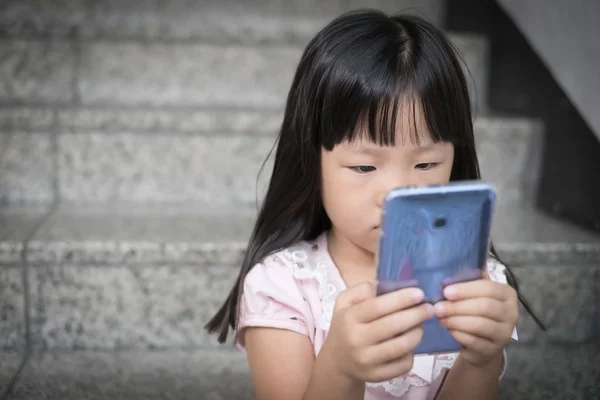 Mädchen benutzt Telefon und ist verärgert — Stockfoto