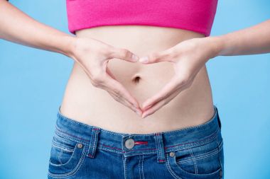 woman showing  heart gesture with belly on the blue background clipart