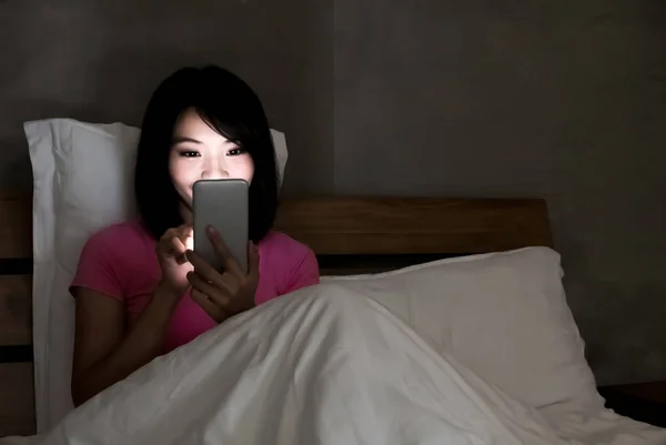 晚上在床上使用电话的妇女 — 图库照片