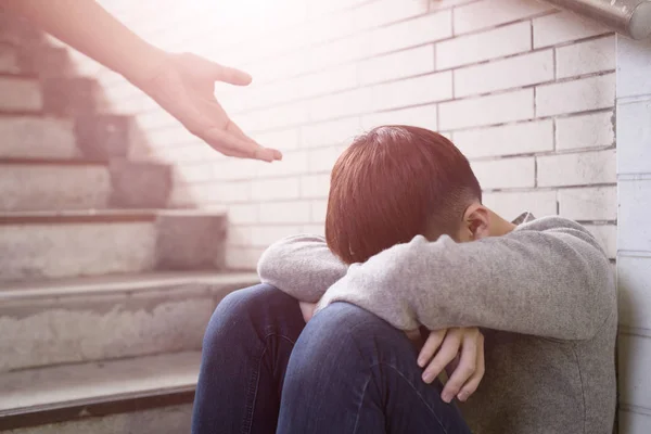 Uomo Depresso Seduto Nel Sottosuolo Con Una Mano Che Viene — Foto Stock