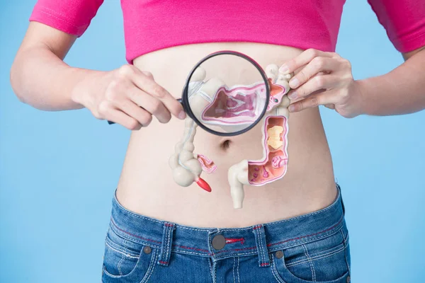 青の背景に大腸癌モデルの女性 — ストック写真