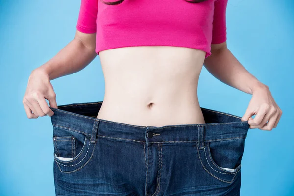 Mujer Vistiendo Jeans Mostrando Pérdida Peso Fondo Rosa —  Fotos de Stock
