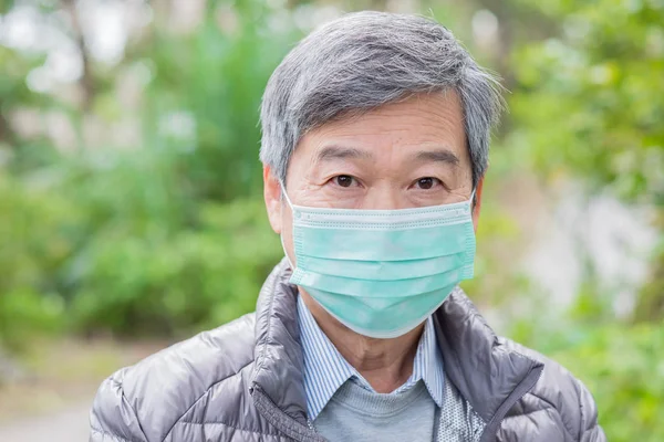 old man  got cold and wearing  mask outdoors