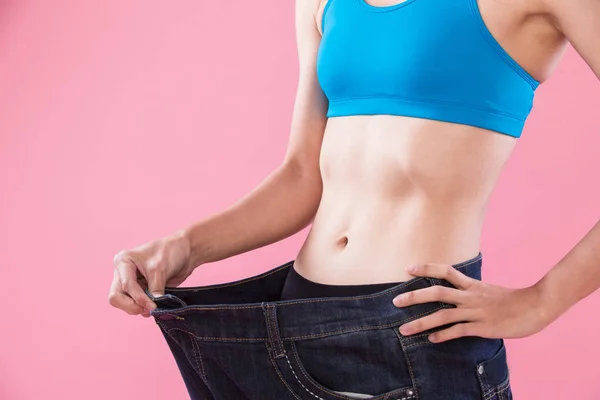 Frau Trägt Jeans Und Zeigt Gewichtsverlust Auf Rosa Hintergrund — Stockfoto