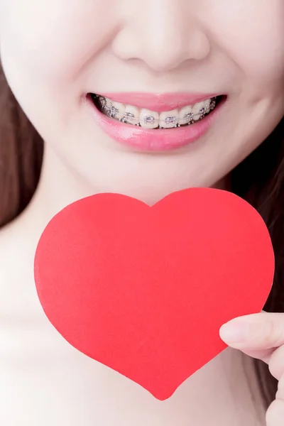 Kobieta Nosząca Aparat Zębach Trzymająca Serce Niebieskim Tle — Zdjęcie stockowe