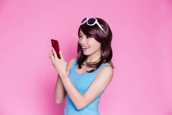 在粉红色背景下使用电话的妇女 — 图库照片