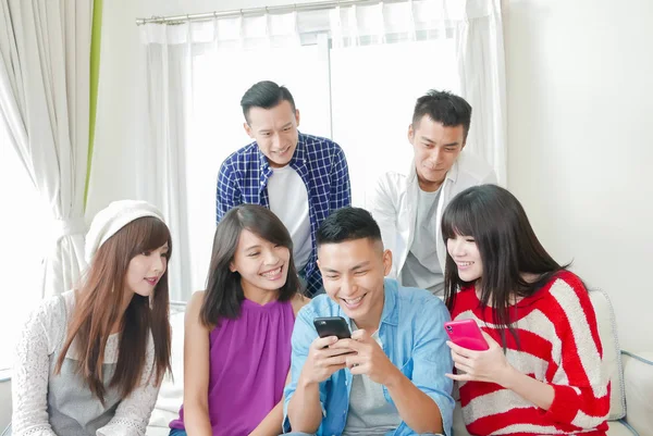 Молодые Люди Используют Телефоны Счастливо Улыбаются — стоковое фото