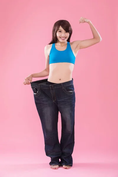 Překvapený Žena Nosí Nadměrné Džíny Ukazuje Úbytek Váhy Růžovém Pozadí — Stock fotografie
