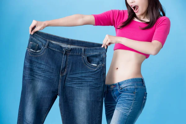 青の背景に体重減少を示す女性 — ストック写真