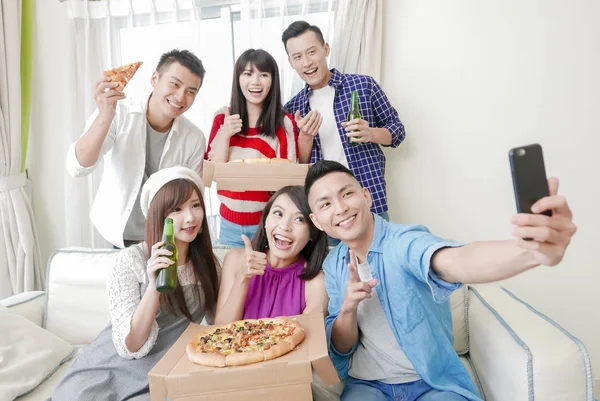 young people eating pizza and taking selfie happily on  party