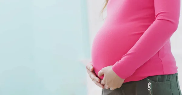 Primo Piano Della Donna Incinta Che Tocca Pancia Sul Letto — Foto Stock