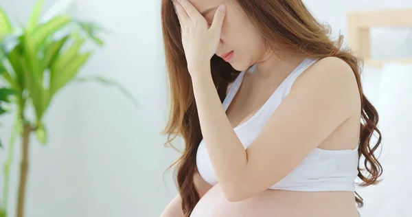 ベッドと感じうつ病の自宅の上に座って妊娠中の女性 — ストック写真