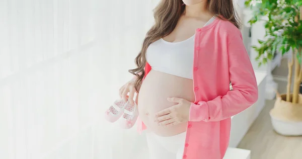 Mujer Embarazada Pie Sosteniendo Pequeños Zapatos Bebé — Foto de Stock