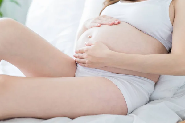 침대에 임신한 여자의 클로즈업 — 스톡 사진