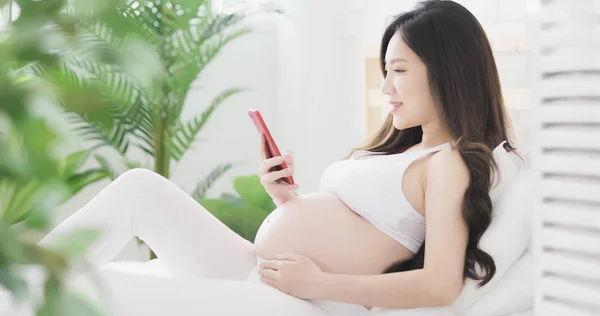 Беременная Женщина Сидит Счастливо Пользуется Телефоном — стоковое фото