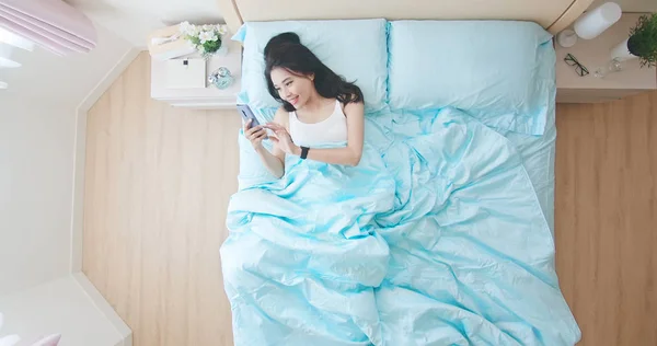 Mulher usar telefone na cama — Fotografia de Stock
