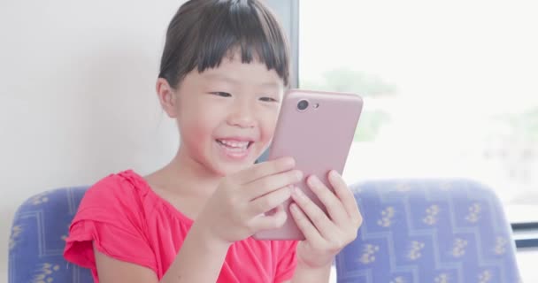 Девочка играет в мобильную игру — стоковое видео