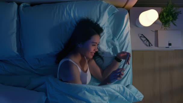 Wanita menggunakan smartphone di tempat tidur — Stok Video