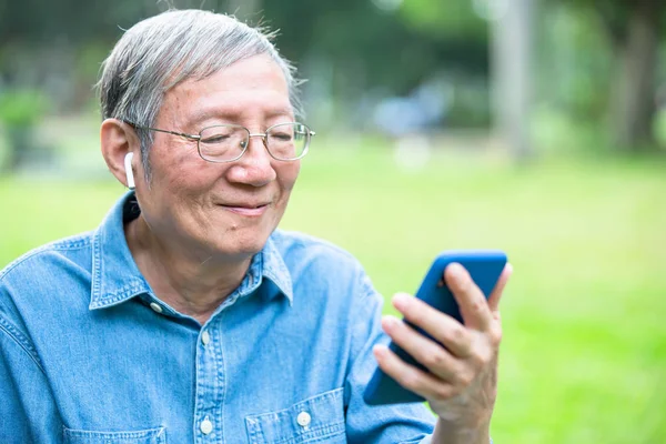 Älterer Mann benutzt Ohrstöpsel — Stockfoto