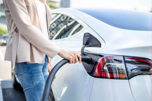 Mujer cargando coche eléctrico —  Fotos de Stock