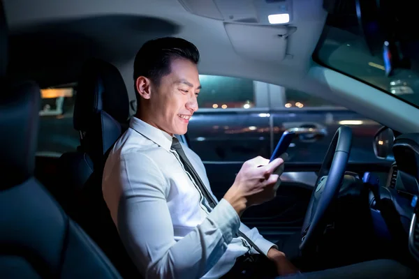 Hombre de negocios utilizar el teléfono inteligente en coche — Foto de Stock