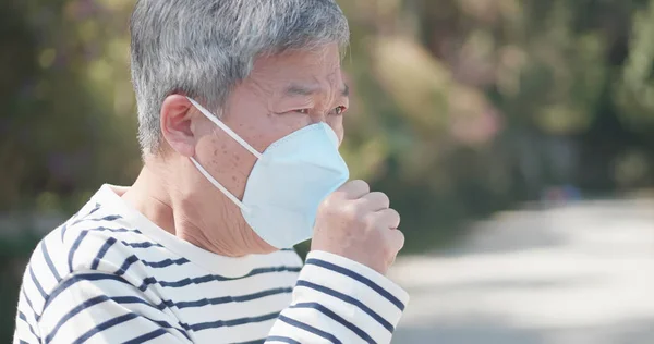 Elder coughs and wears mask — Stock Photo, Image