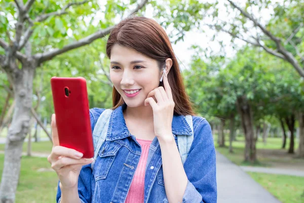 Asiatisk jente bruker telefon utendørs – stockfoto