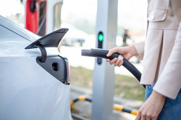 Mujer cargando coche eléctrico —  Fotos de Stock