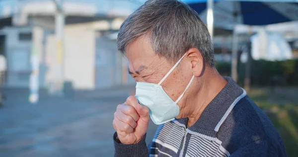 Elder coughs and wears mask — Stock Photo, Image