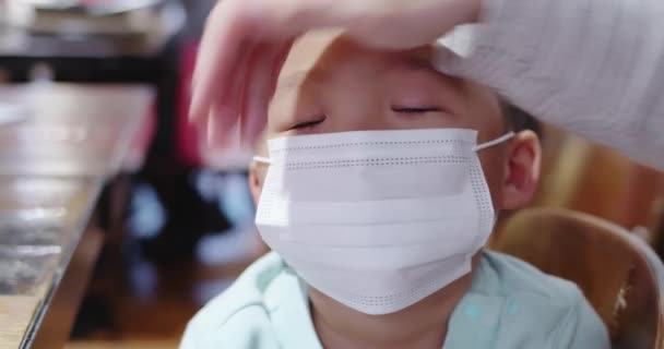 A szülők maszkot viselnek a gyerekeken — Stock videók