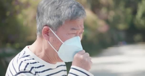 Старейшина кашляет и носит маску — стоковое видео