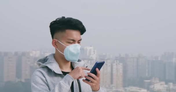 Mann benutzt Smartphone mit Maske — Stockvideo