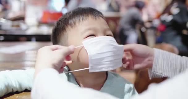 Родители носят маски для детей — стоковое видео