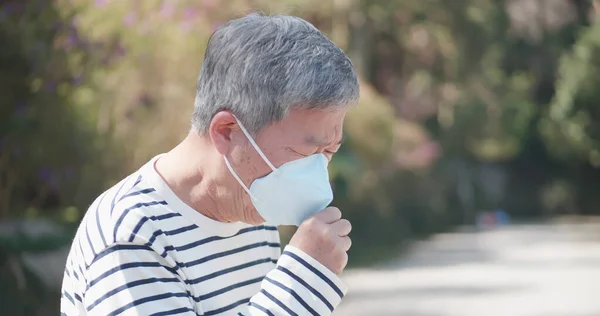 Elder coughs and wears mask — Stock Photo, Image