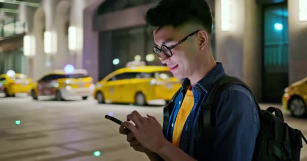 Mężczyzna używać taksówki aplikacji na zewnątrz — Wideo stockowe