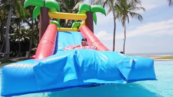 Girl playing on inflatable slide — Stock Video