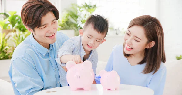 Família Economizando Dinheiro Colocando Moedas Banco Porquinho — Fotografia de Stock