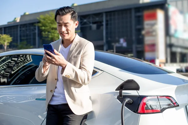 Asyalı Adam Beklerken Akıllı Telefon Kullanır Güç Kaynağı Arabadaki Aküyü — Stok fotoğraf