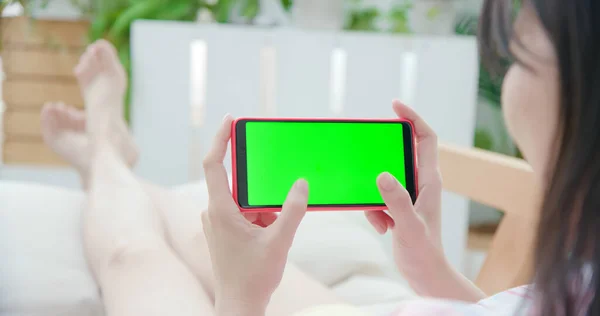 女人在家里用绿色屏幕的智能手机 — 图库照片