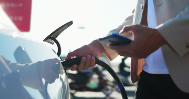 Заряжает электромобиль — стоковое видео