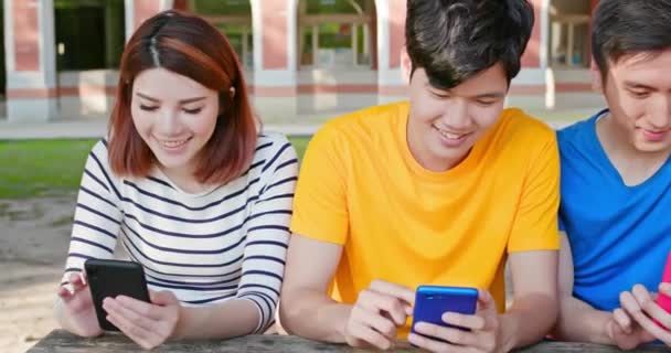 Молодые студенты используют смартфон — стоковое видео