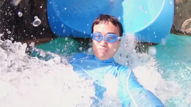 Hombre asiático en tobogán acuático — Vídeos de Stock