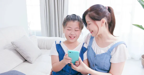 Tyttäret Äiti Käyttävät Älypuhelinta Onnellisesti Kotona — kuvapankkivalokuva