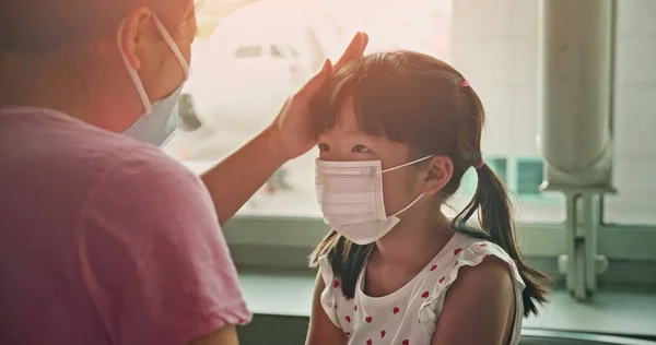 아시아의 부모들은 공항내에서 전염될 수있는 전염병때문에 마스크를 자녀들에게 — 스톡 사진