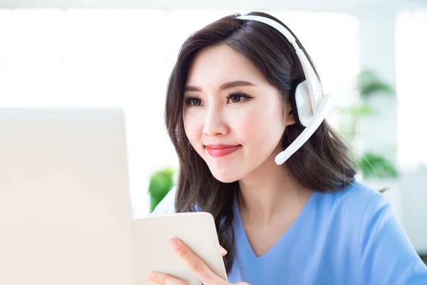 远程工作的概念 亚洲女性使用电脑和耳机话筒参加家庭视频会议 — 图库照片