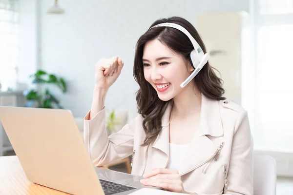 アジアのビジネス女性は ビデオ会議中に成功した仕事の成果を得ると彼女は自宅でテレワークにラップトップを使用します — ストック写真